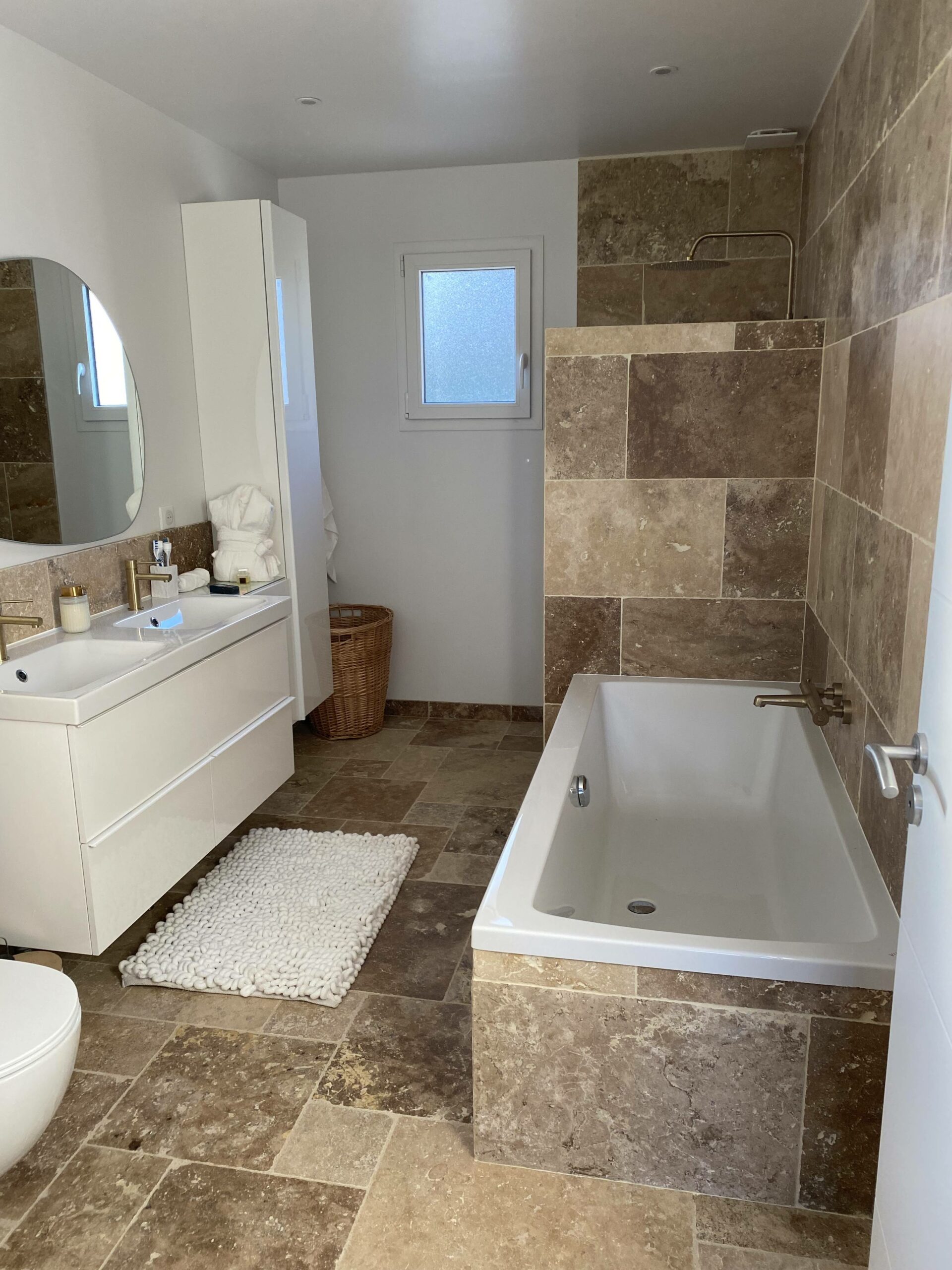 Rénovation salle de bain avec baignoire et carrelage effet pierre